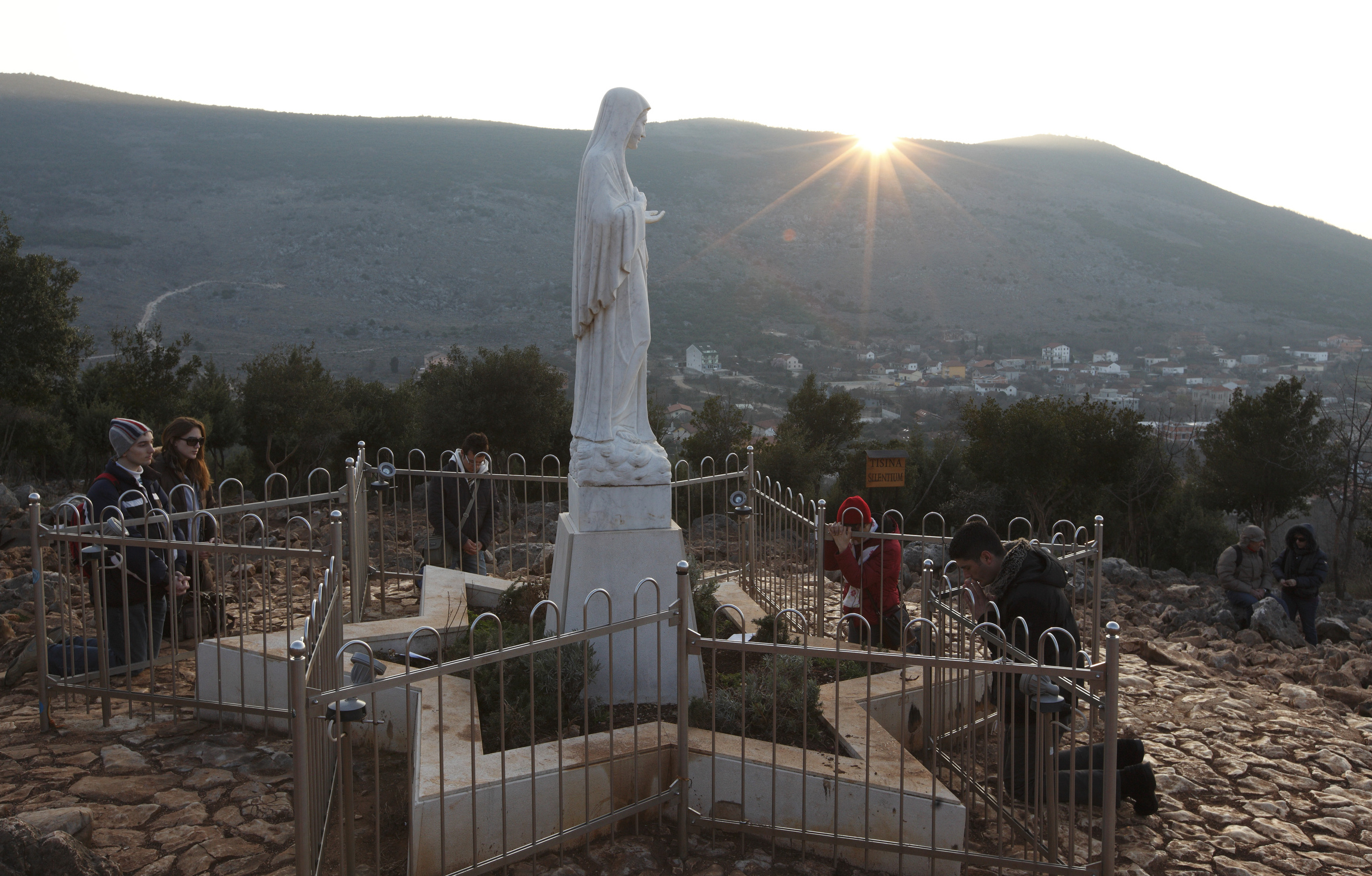 Pilgrims pray around a statue of Mary on Apparition Hill in Medjugorje, Bosnia-Herzegovina, Feb. 26. The site is where six village children first claimed to see Mary in June 1981. A Vatican-appointed commission is studying the alleged Marian apparitions at Medjugorje. CNS photo/Paul Haring) (Feb. 28, 2011) See MEDJUGORJE-PILGRIMS Feb. 28, 2011.